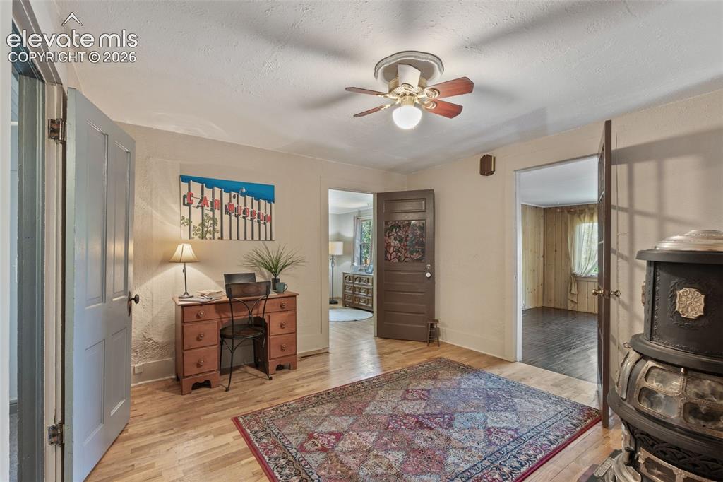 Image 14 of 40: Room featuring light wood-finish flooring, a ceiling fan, and multiple door