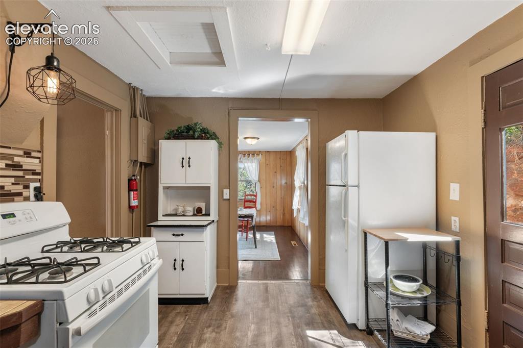 Image 18 of 40: Kitchen space featuring wood-finish flooring, white cabinetry, a built-in o