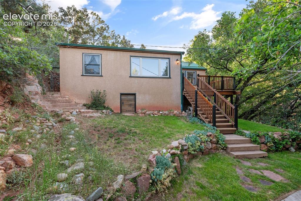 Image 2 of 40: Terraced yard featuring a stone retaining wall, concrete steps, and lush gr