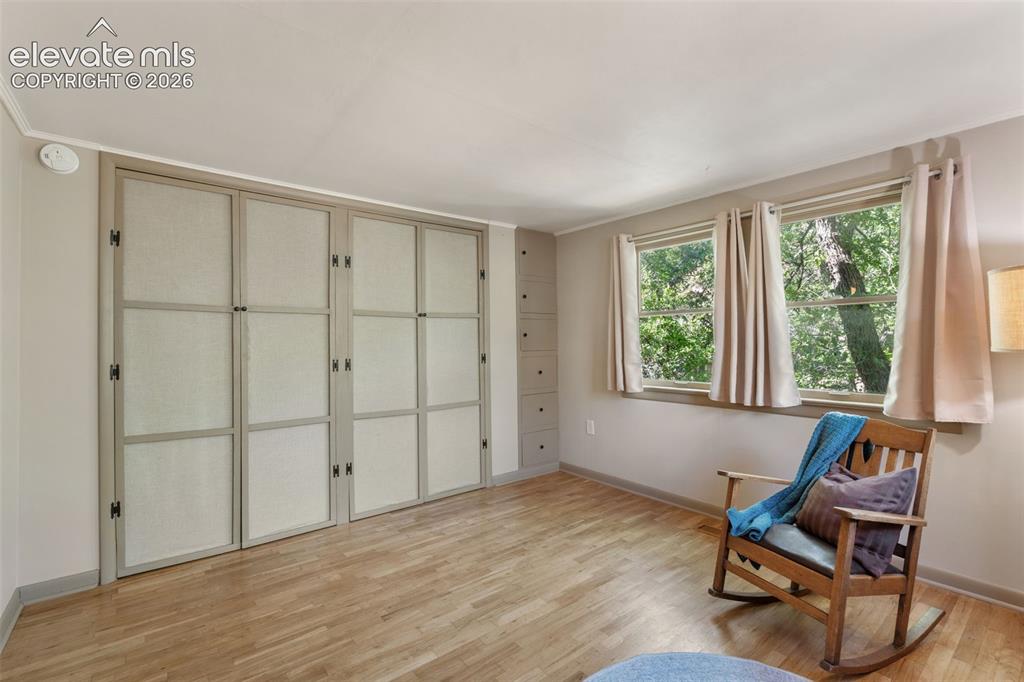 Image 25 of 40: Room featuring wood-finish flooring, two large windows, built-in cabinetry,