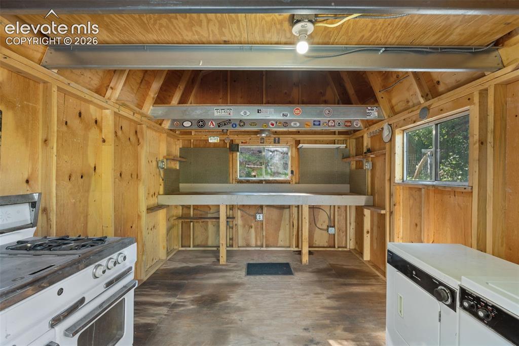 Image 35 of 40: Utility space featuring natural wood paneling, exposed beam ceiling, built-
