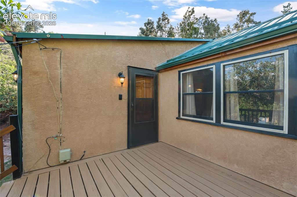 Image 6 of 40: Outdoor deck with wood-finish planks and stucco exterior
