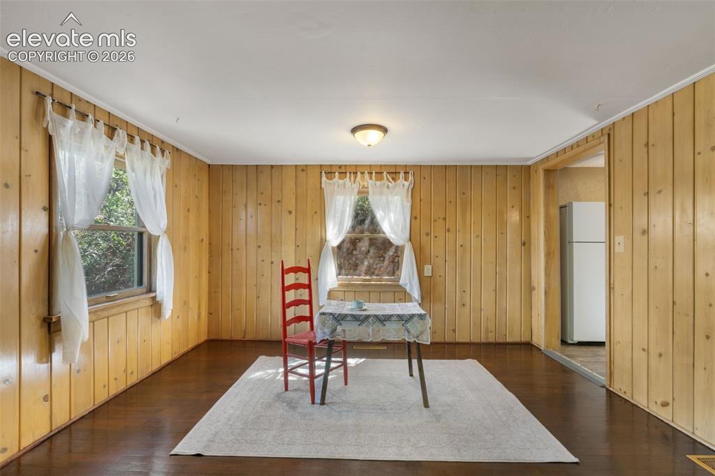Image 9 of 40: Interior space featuring wood-paneled walls and dark wood-finish flooring