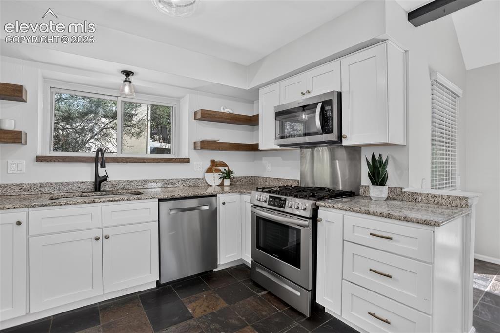 Image 8 of 30: Granite countertops & gas range
