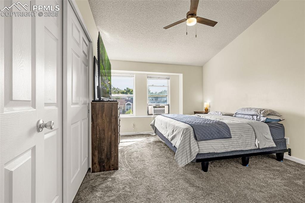 Image 15 of 30: Bedroom featuring carpet, a textured ceiling, a ceiling fan, and a closet