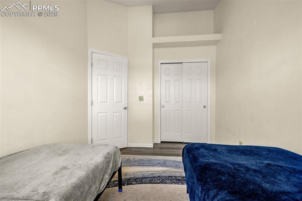 Image 19 of 30: Bedroom with a closet, wood finished floors, and a towering ceiling