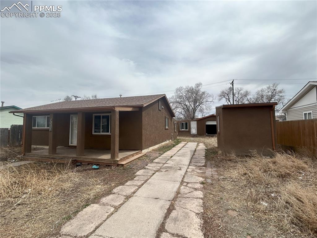 Image 10 of 16: View of side of home with driveway, stucco siding, and roof with shingles