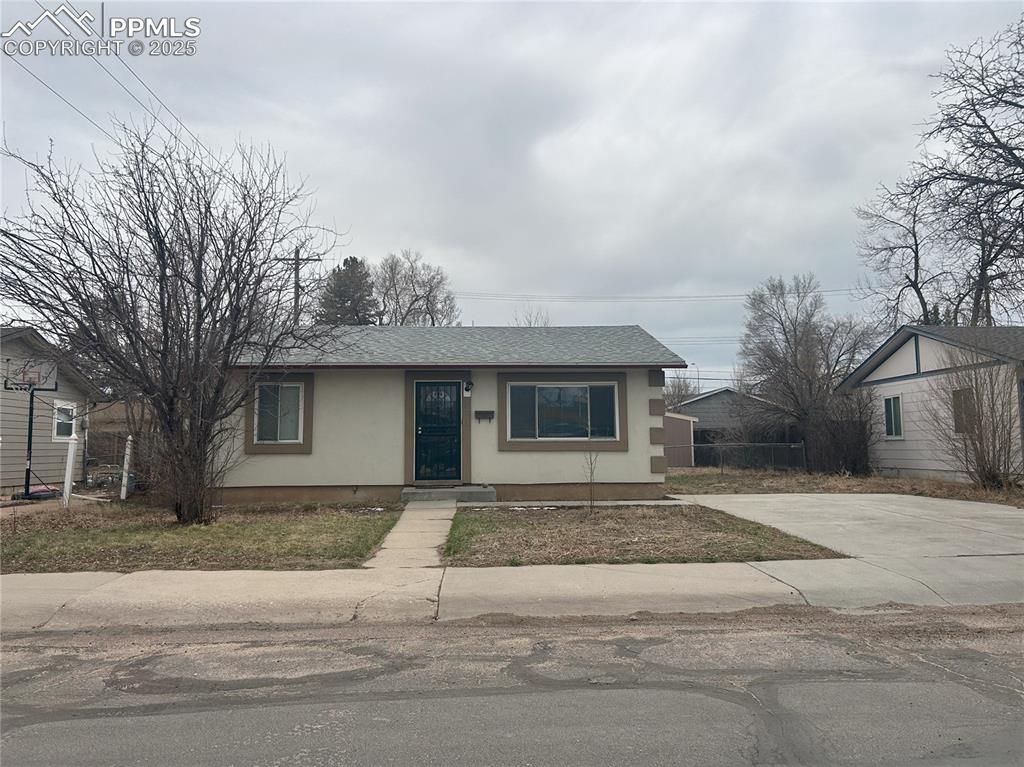 Image 12 of 16: View of front facade with stucco siding, driveway, and a shingled roof