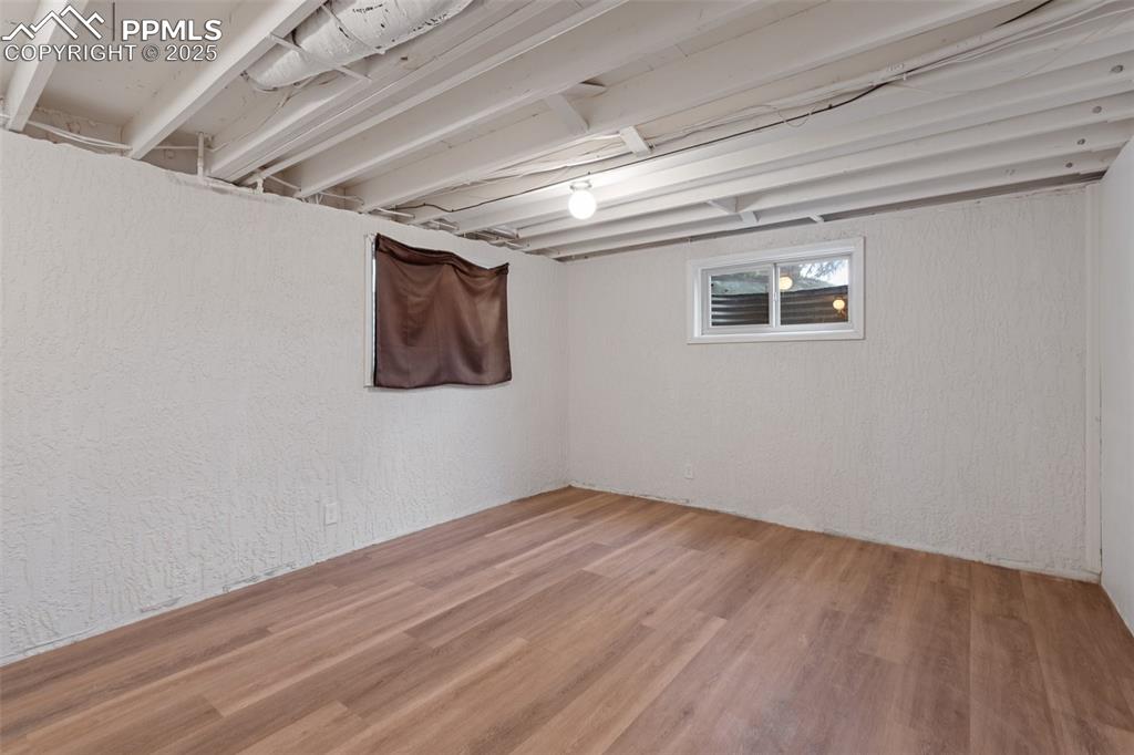 Image 22 of 25: Basement Bedroom featuring a closet, a textured wall, and wood-finished fl