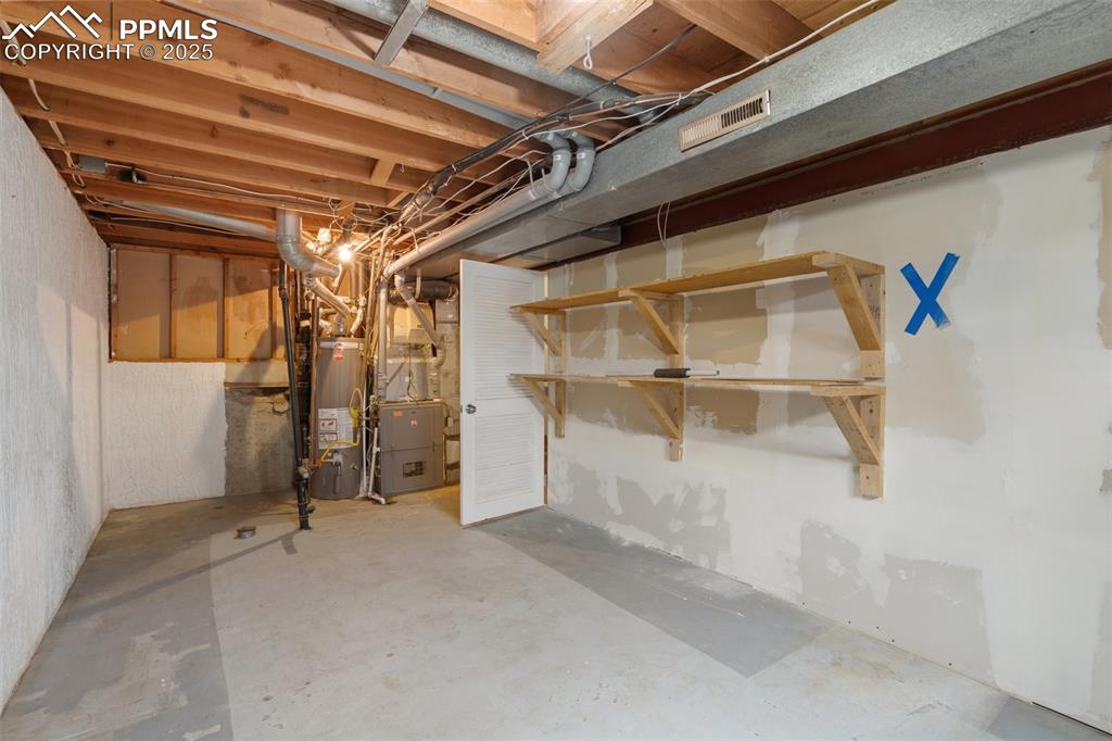 Image 23 of 25: Utility room featuring a furnace unit and a water heater