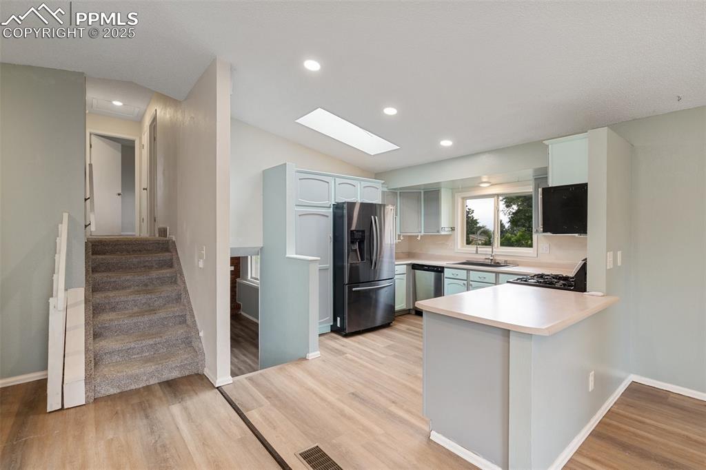 Image 7 of 25: Open concept main level Kitchen, Dining room, and Living room light wood-st