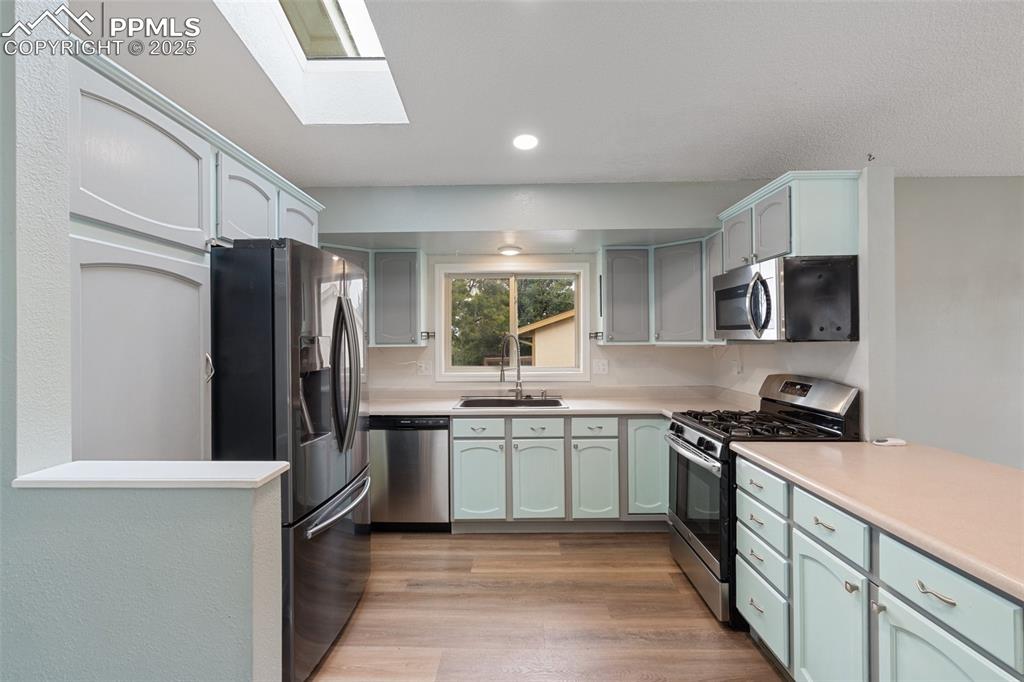 Image 8 of 25: Kitchen with light countertops, a skylight, stainless steel appliances, rec