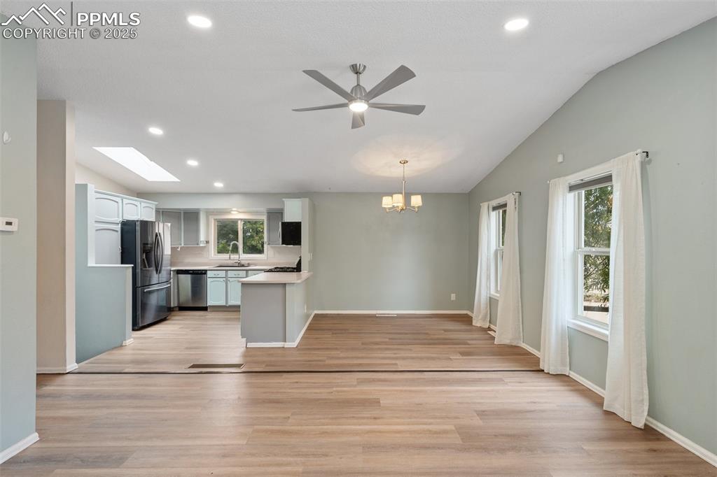 Image 9 of 25: Open concept main level Kitchen, Dining room, and Living room light wood-st