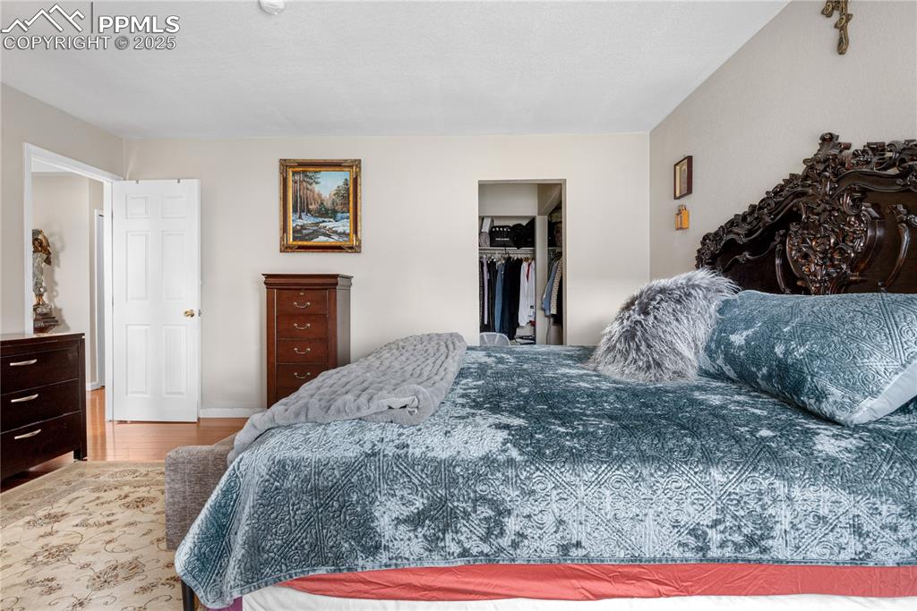 Image 14 of 38: Bedroom featuring a spacious closet, wood finished floors, and a closet