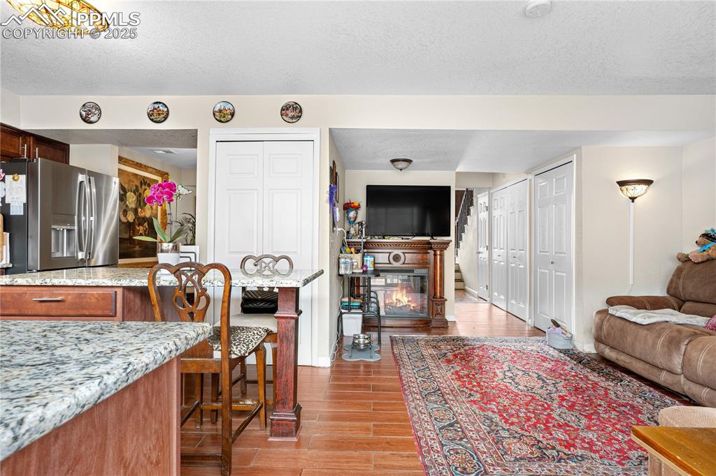 Image 24 of 38: Living area featuring wood finished floors, a textured ceiling, and a glass