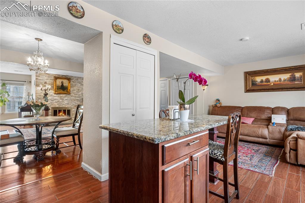 Image 25 of 38: Kitchen featuring dark wood finished floors, open floor plan, a textured ce