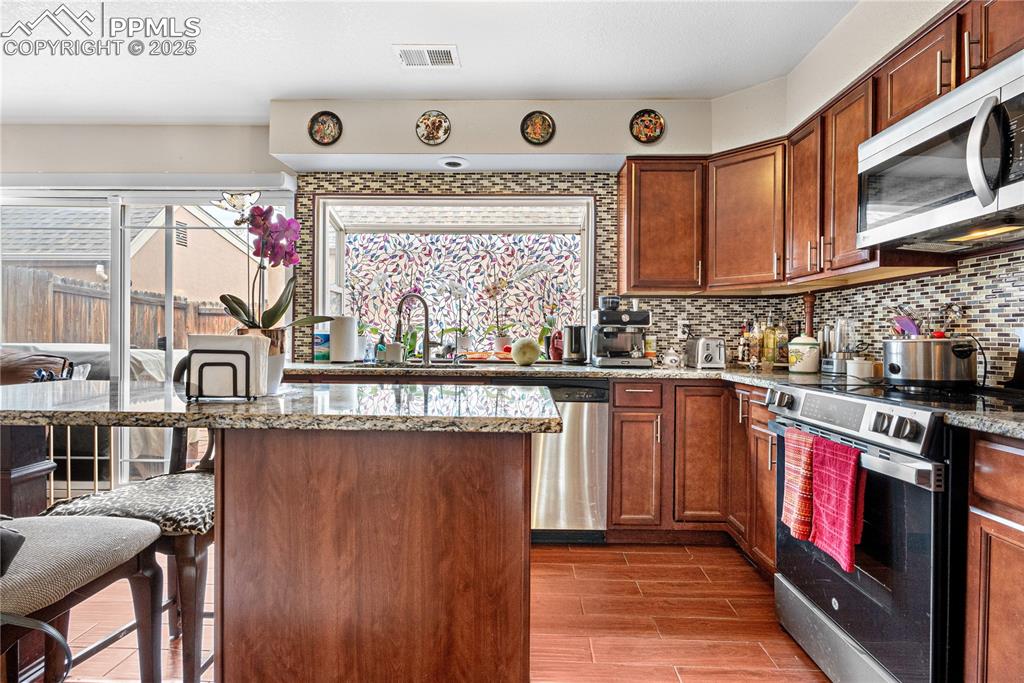 Image 28 of 38: Kitchen with appliances with stainless steel finishes, healthy amount of na