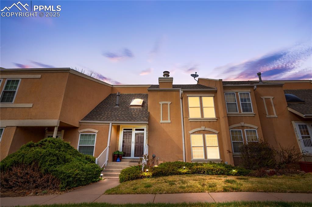 Image 3 of 38: View of property featuring stucco siding, a chimney, and a shingled roof
