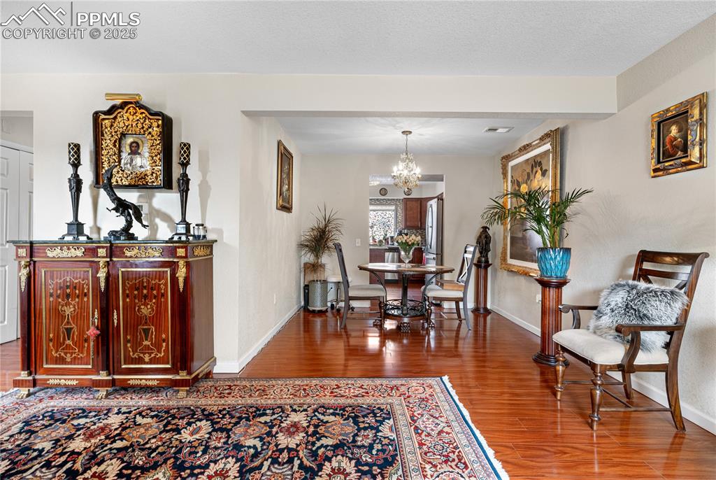 Image 32 of 38: Dining area featuring a chandelier and wood finished floors