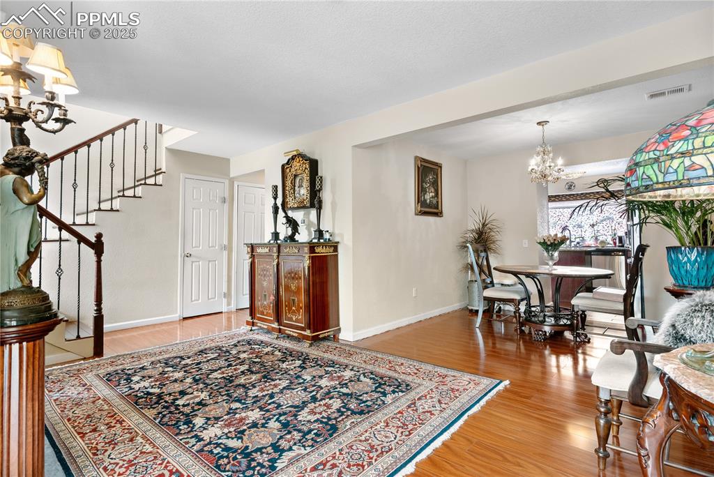 Image 33 of 38: Entryway featuring a chandelier, light wood-style floors, and stairs