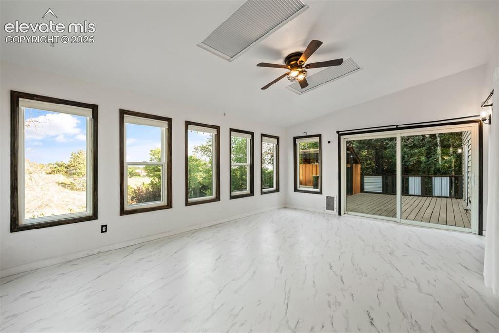 Image 14 of 50: Sunroom with Walk Out to Deck