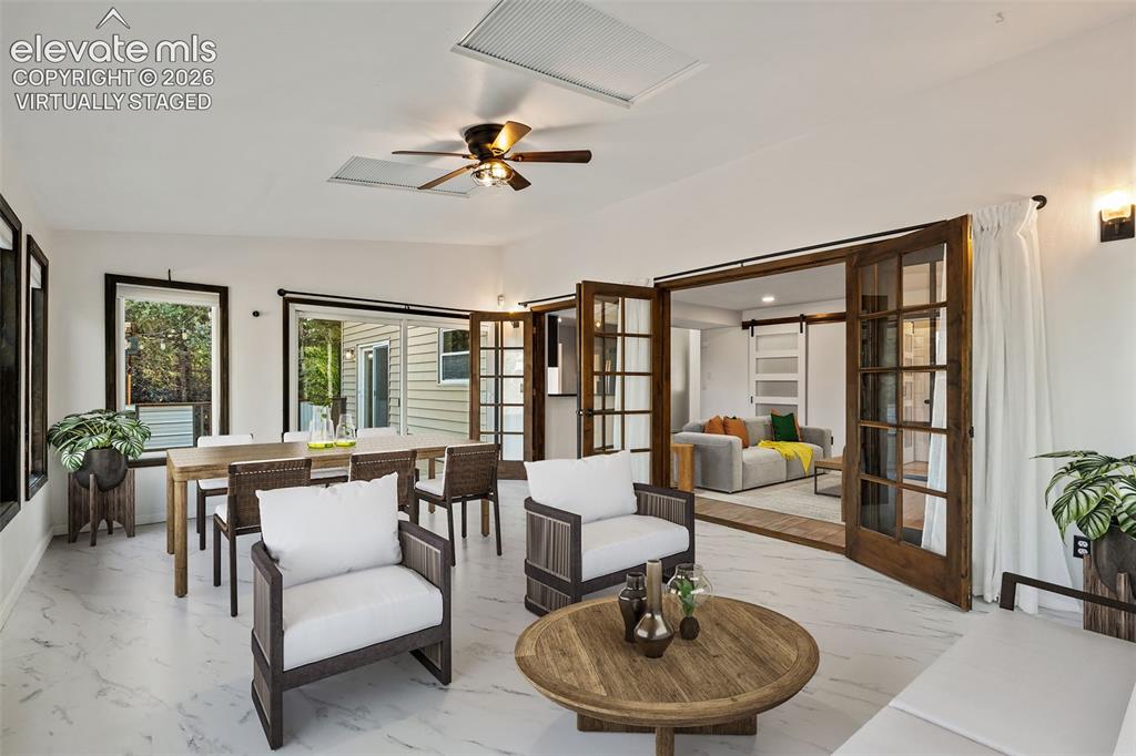 Image 15 of 50: Virtually Staged Sunroom with Walk Out to Deck