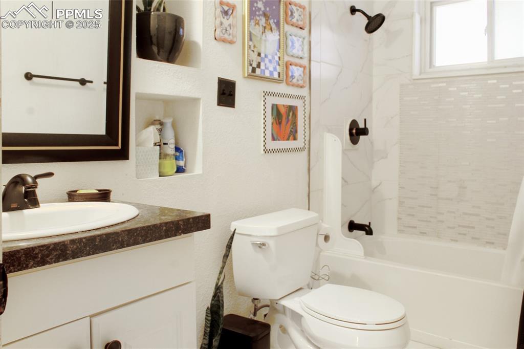 Image 11 of 28: Bathroom featuring shower / bath combo with shower curtain and vanity
