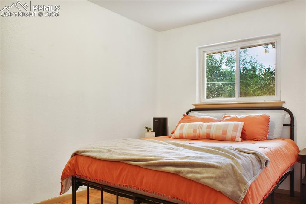 Image 12 of 28: Bedroom with wood finished floors and baseboards