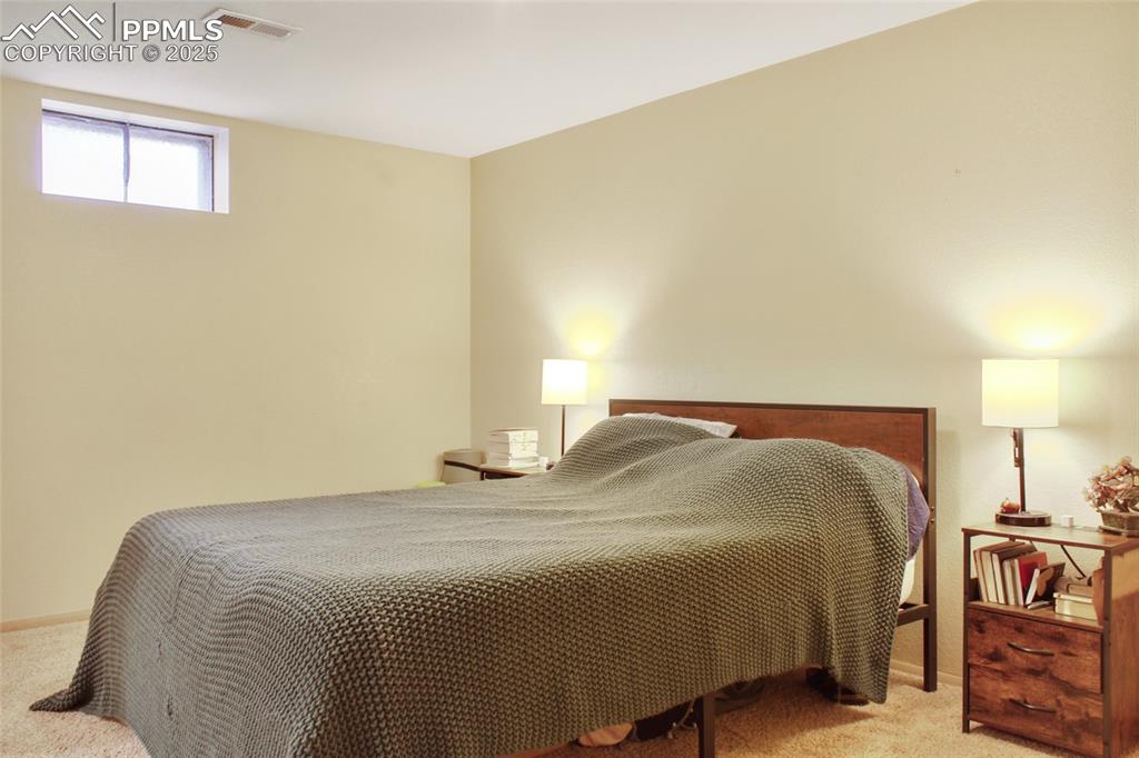 Image 13 of 28: Bedroom featuring light carpet