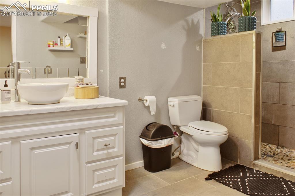 Image 15 of 28: Bathroom featuring vanity, a stall shower, light tile patterned flooring, a