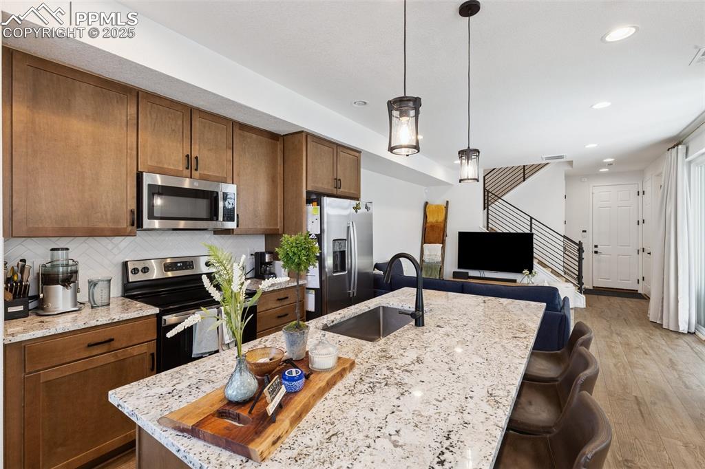 Image 10 of 46: Kitchen featuring stainless steel appliances, maple cabinets, an oversized 