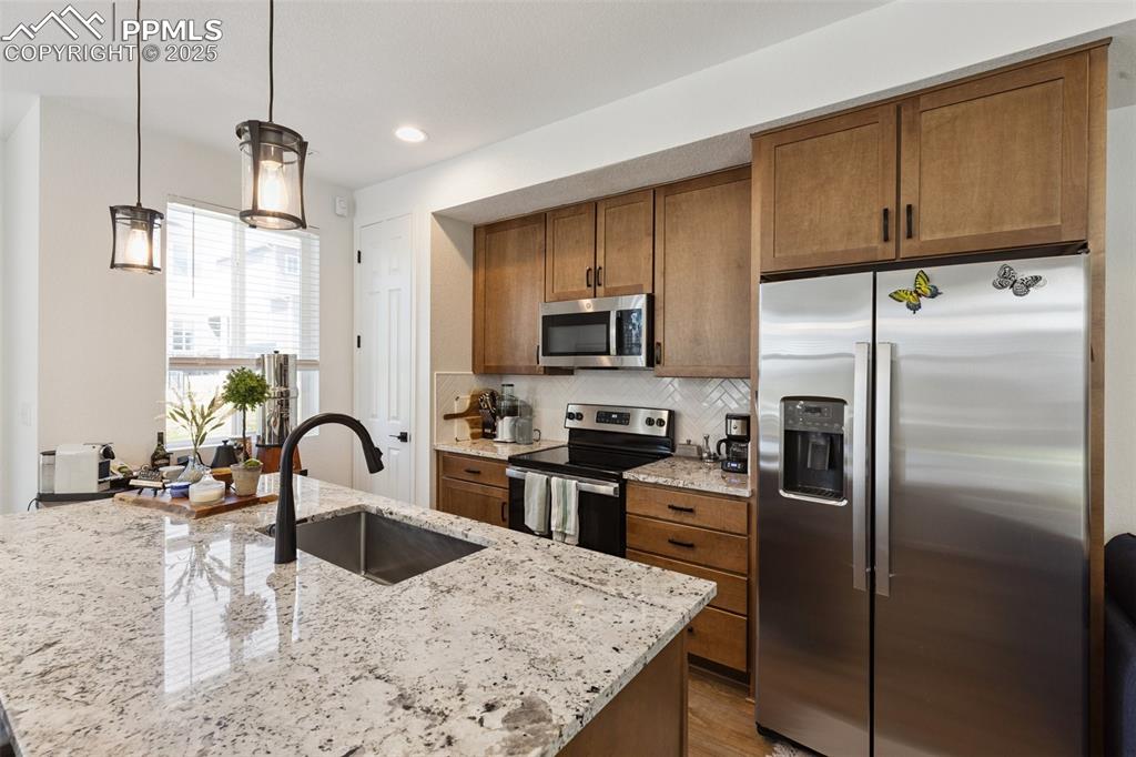 Image 11 of 46: Kitchen featuring stainless steel appliances, maple cabinets, an oversized 