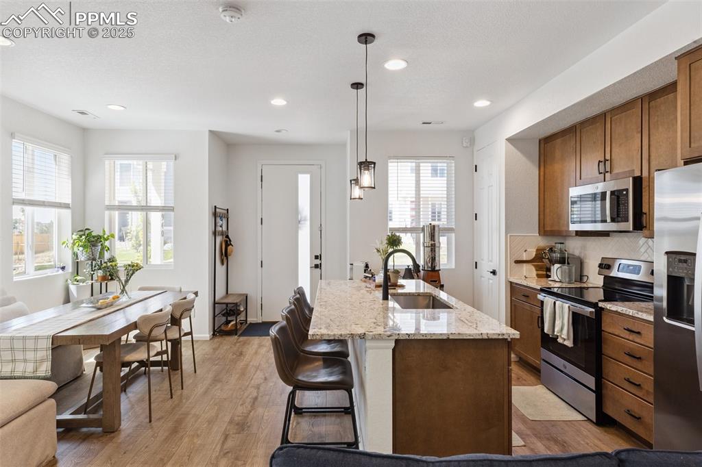 Image 14 of 46: Kitchen and dining room view featuring stainless steel appliances, maple ca
