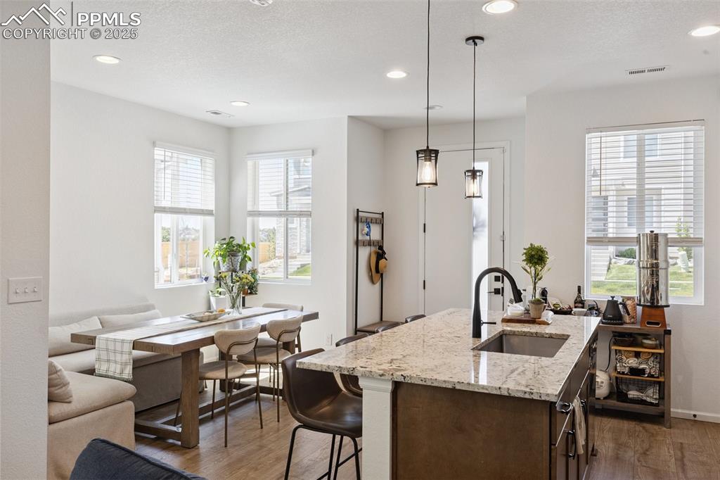 Image 15 of 46: Kitchen and dining room view, oversized island, natural stone countertops, 