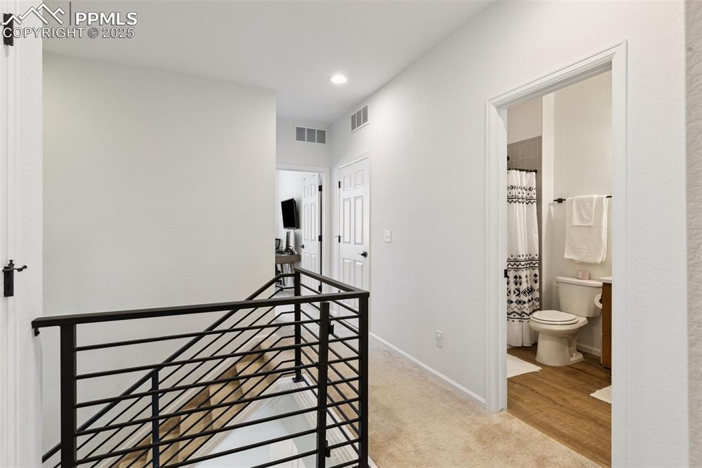 Image 20 of 46: Hallway with an upstairs landing, recessed lighting, and carpet floors