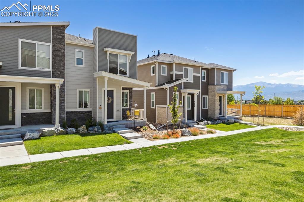 Image 3 of 46: Front view of property with a mountain view and grass community area