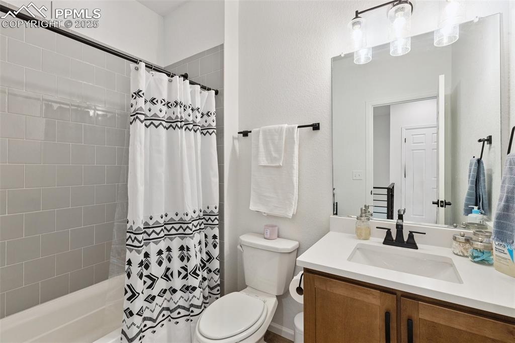 Image 31 of 46: Bathroom with maple cabinet vanity and shower / tub combo