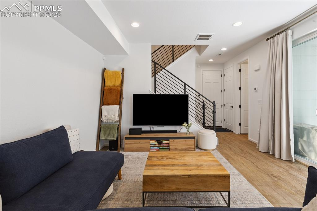 Image 6 of 46: Living area with stairs, access to covered patio, Luxury Vinyl Tile floorin