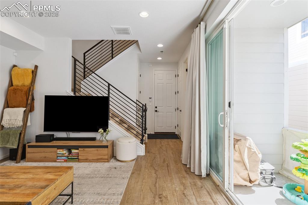 Image 8 of 46: Living area with stairs, access to covered patio, Luxury Vinyl Tile floorin