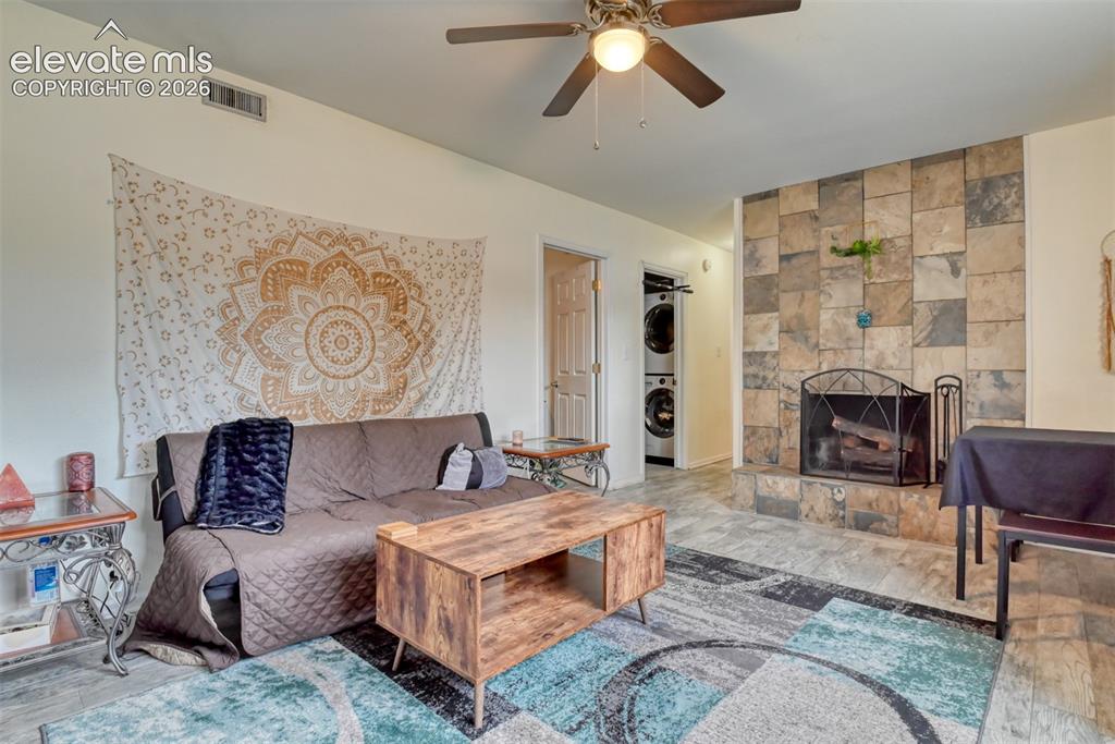 Image 13 of 46: Living area featuring a stone-clad fireplace and hearth