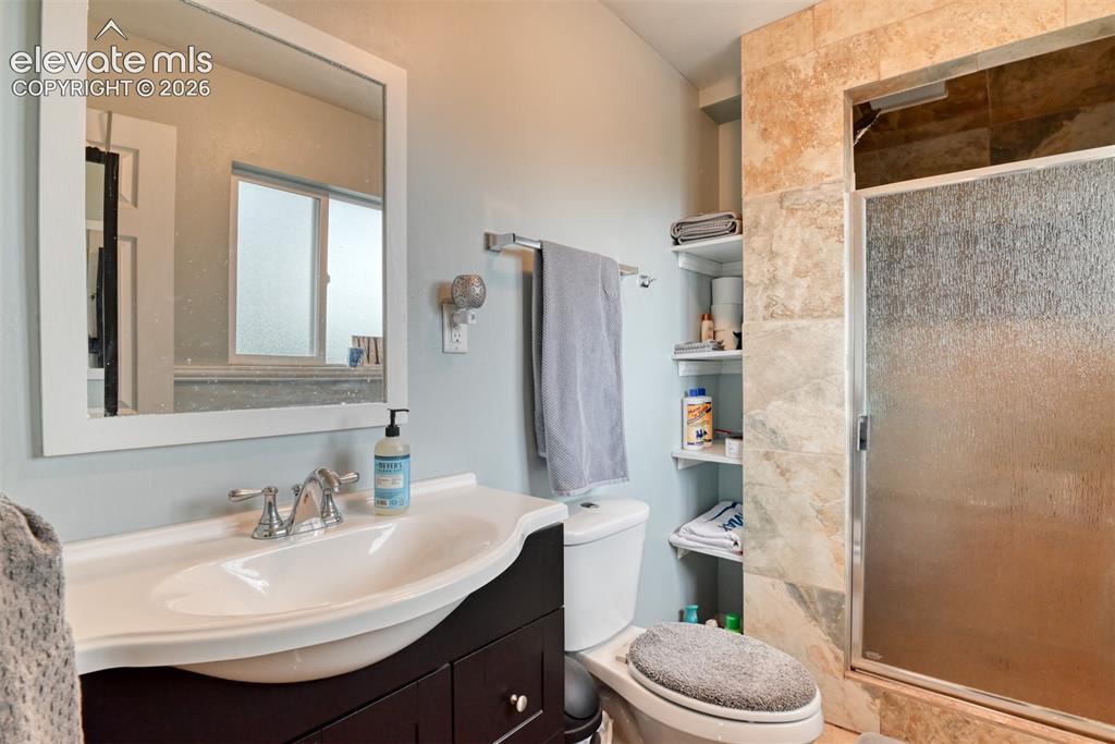 Image 18 of 46: Bathroom featuring a dark wood-finish vanity with an integrated white sink,
