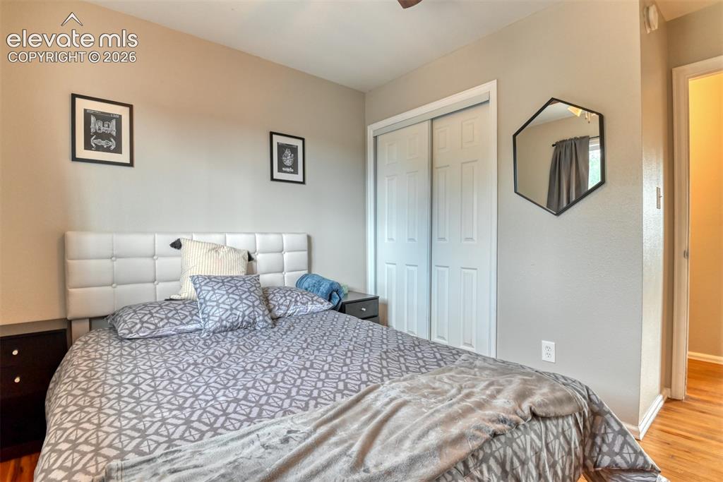 Image 26 of 46: Bedroom featuring neutral wall colors, wood-finish flooring, and a white pa