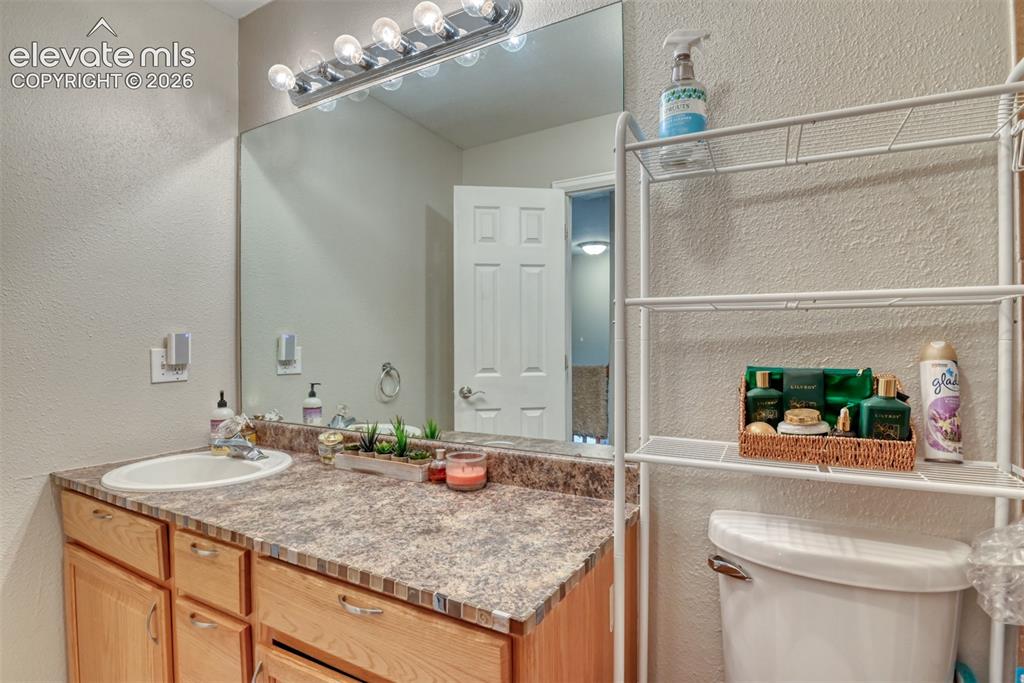 Image 35 of 46: Bathroom featuring a single vanity with an integrated sink, a speckled coun