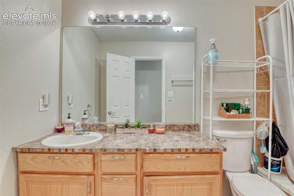 Image 36 of 46: Bathroom vanity with an integrated sink, laminate countertop, and wood-fini