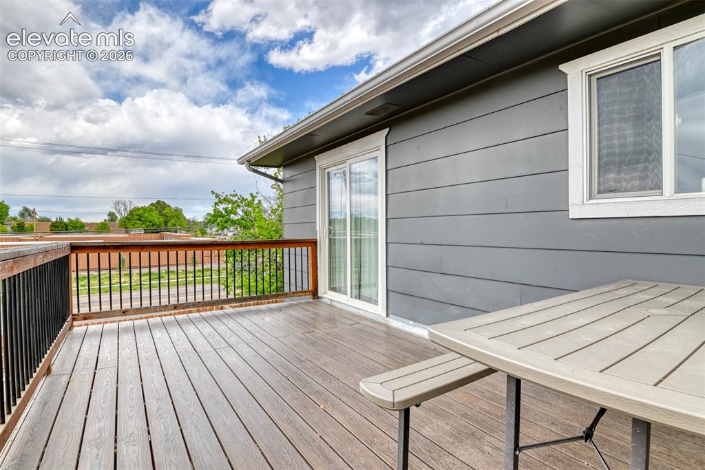 Image 38 of 46: Outdoor deck featuring composite decking, wood railings with black metal sp