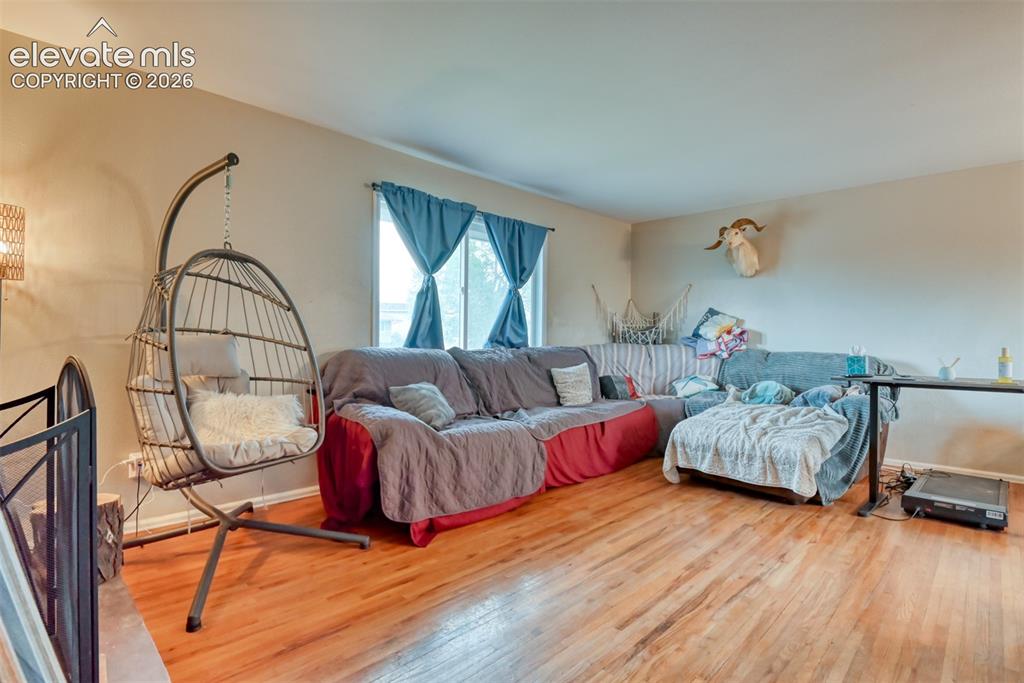 Image 4 of 46: Living area featuring wood-finish flooring, light-toned walls, and a window