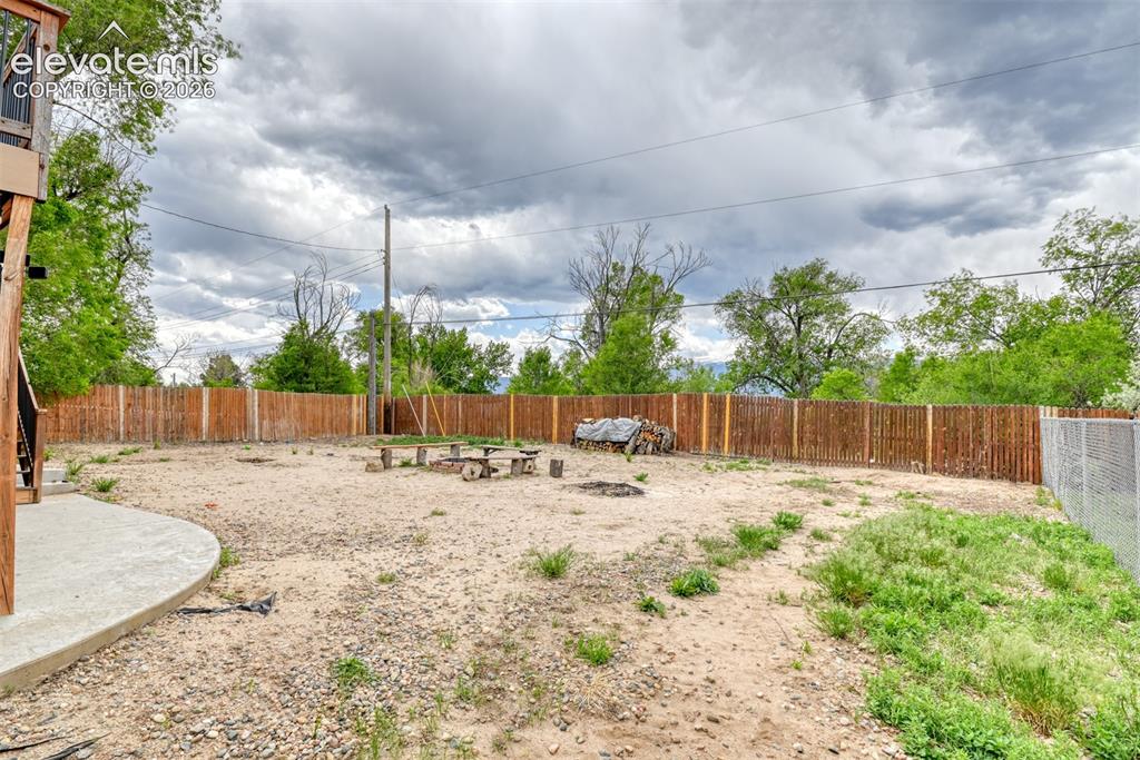 Image 45 of 46: Expansive outdoor space featuring a wood privacy fence, a concrete patio, a