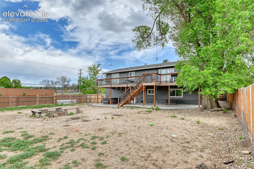 Image 46 of 46: Spacious backyard with a wood privacy fence and mature trees