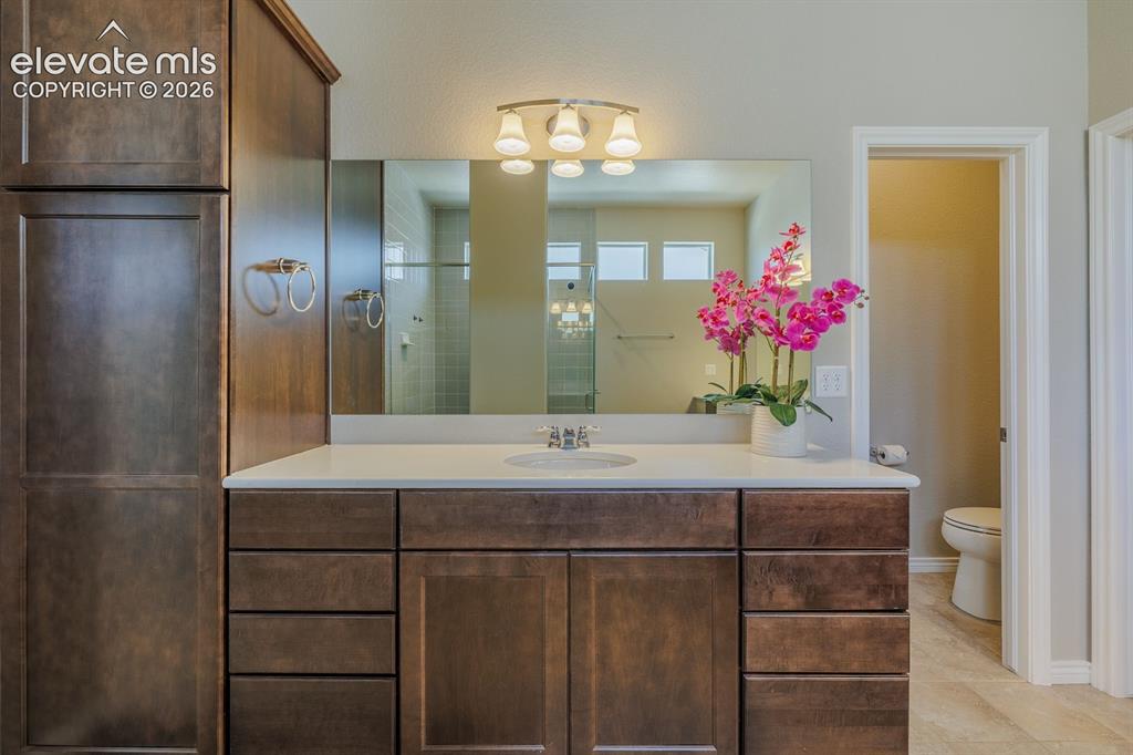 Image 25 of 47: main bedroom with double sinks, walk in clset and access to laundry room