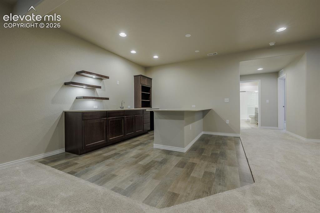 Image 33 of 47: wet bar with LVP flooring